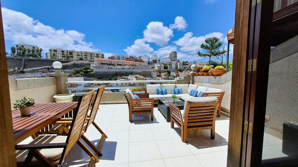 Un patio con una mesa y sillas en un balcón. en Vik Altavista, en Las Palmas de Gran Canaria