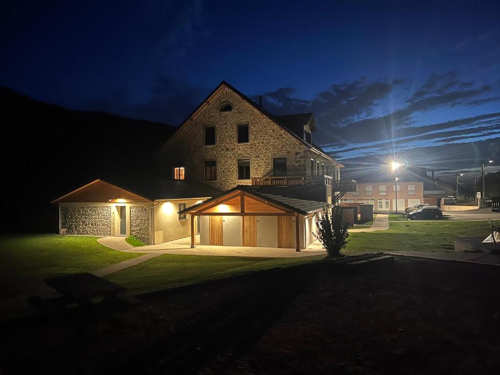 une maison éclairée la nuit dans la cour dans l'établissement Gite Roche Des Ducs avec Piscine toute l'année, Spa, Sauna, Hammam, à Rochesson