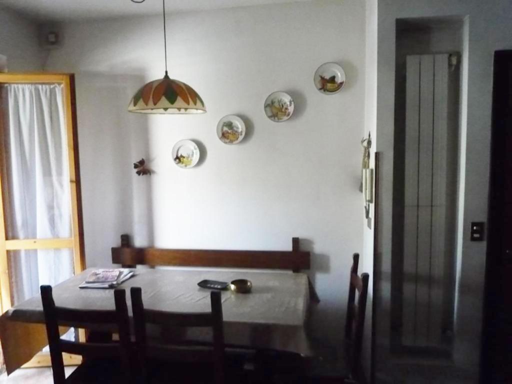 comedor con mesa y algunos platos en la pared en Casa Corone, en Alfedena