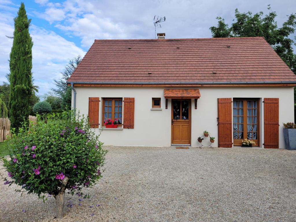 a small white house with a red roof at Charmante maison in Lacs