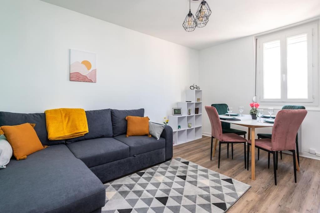 - un salon avec un canapé bleu et une table dans l'établissement LE SAINT CLEMENT B AVEC SALLE DE SPORT, à Rouen