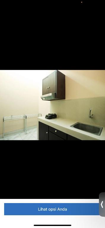 uma cozinha com um lavatório e uma bancada em Reza homestay em Kubang