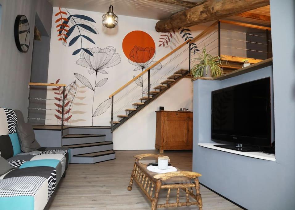 sala de estar con TV y escalera en Domaine Ostau Montplaisant, en Ponlat-Taillebourg