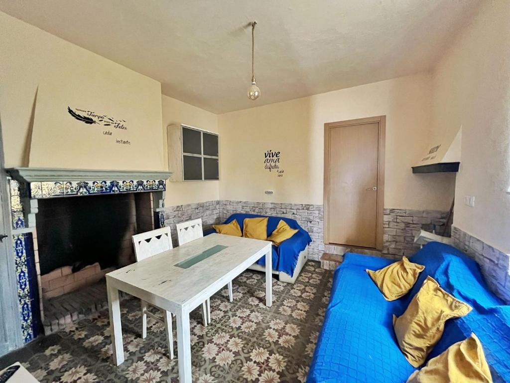 a living room with a table and blue cushions at ALOJAMIENTO RURAL AN CA LA ABUELA PILAR in El Real de la Jara