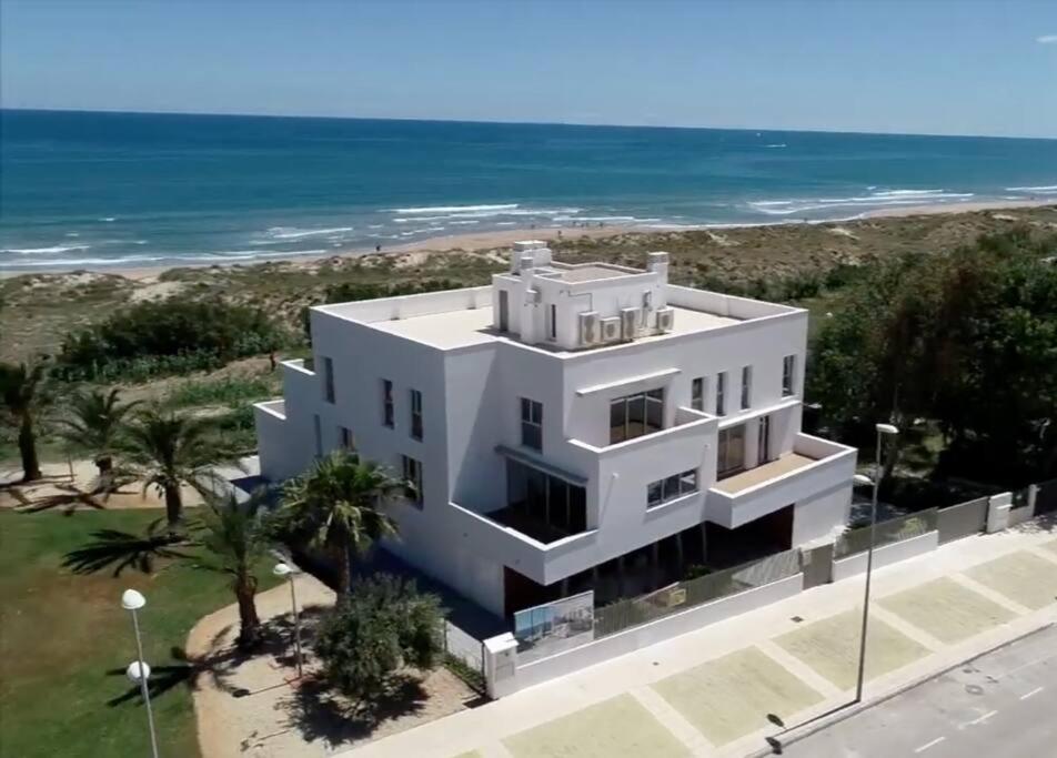 ein weißes Haus mit dem Ozean im Hintergrund in der Unterkunft Orilla del mar in Oliva