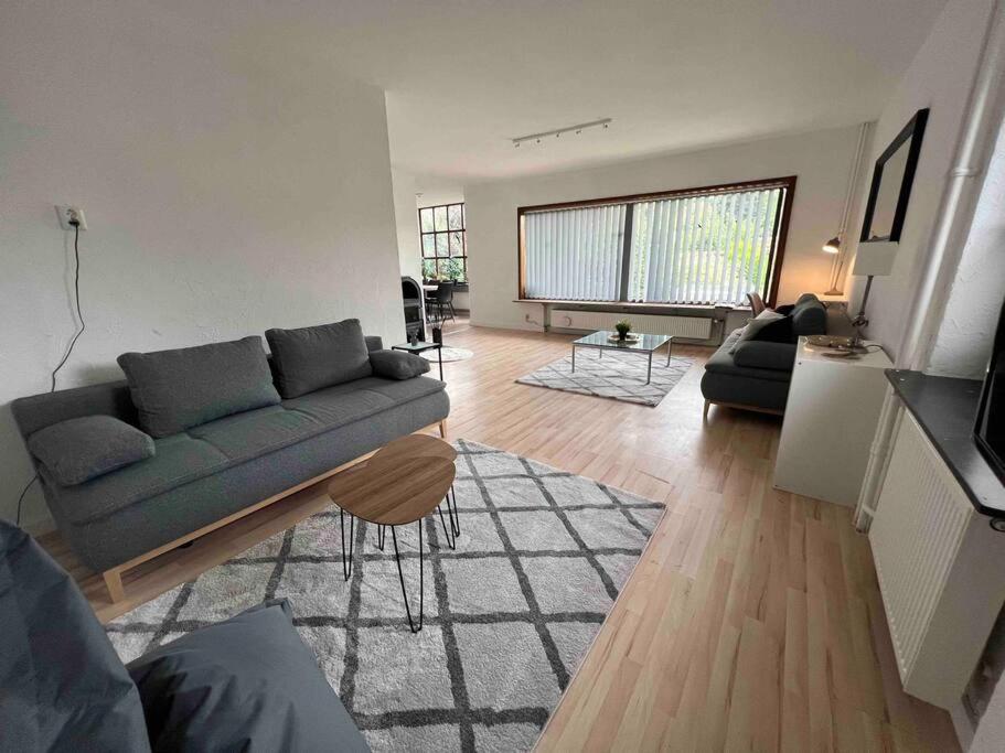 sala de estar con sofá y mesa en Villa Höpen 125qm 4 Schlafzimmer Citynah 5 Zi. Parkplatz Terasse WIFI, en Seevetal