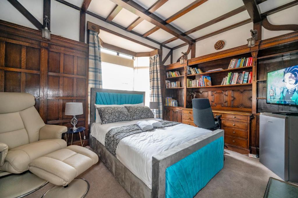 een slaapkamer met een bed, een tv en een stoel bij *RG9bC* For your most relaxed & Cosy stay + Free Parking + Free Fast WiFi * in Moortown