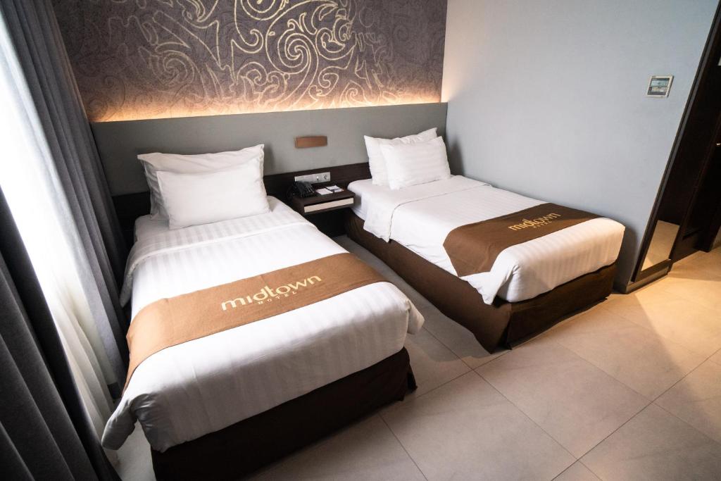 Postel nebo postele na pokoji v ubytování Midtown Hotel Samarinda