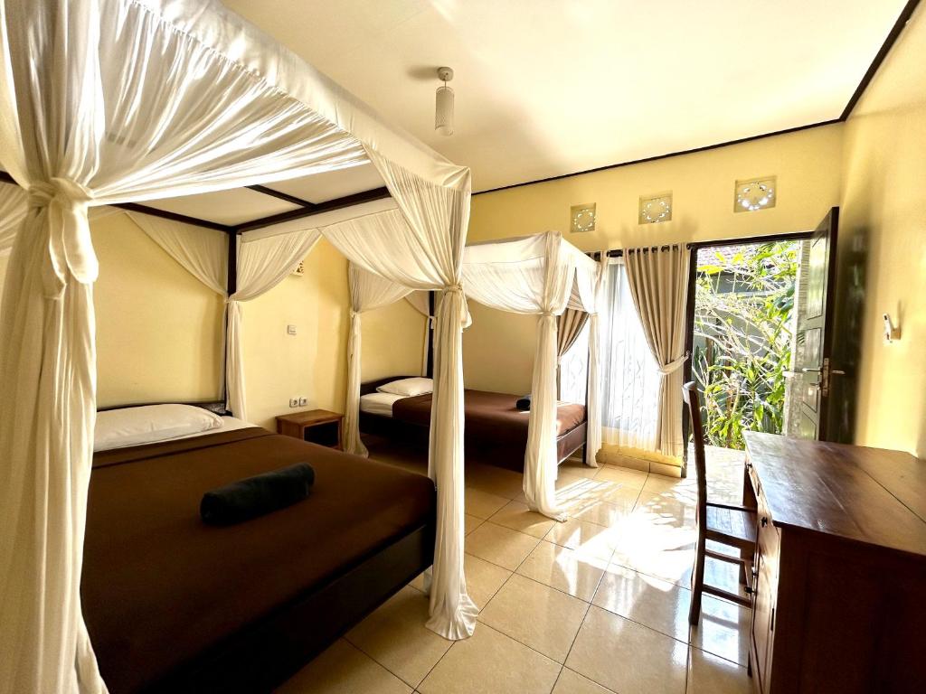 a bedroom with a canopy bed and a desk at Tregge Surf Camp Uluwatu in Uluwatu