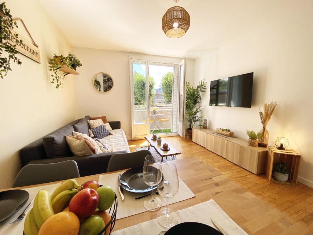 - un salon avec un canapé et une table avec des fruits dans l'établissement Le Bourget, Grand appartement proche du centre, à Grenoble
