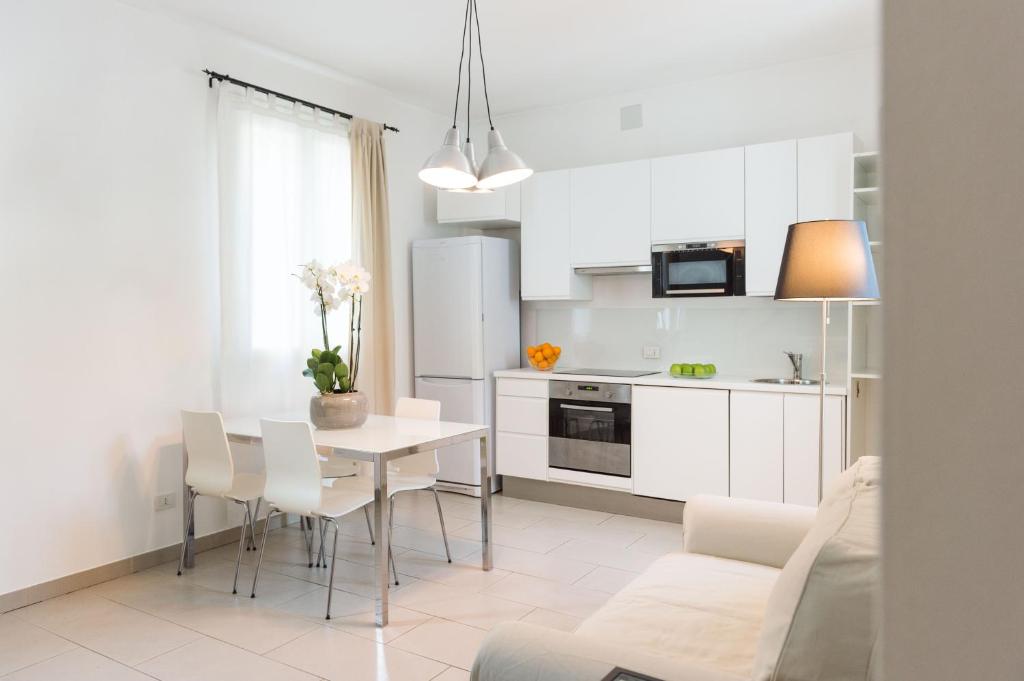 Il comprend une cuisine et un salon avec une table et des chaises. dans l'établissement Appartamenti Cervia, à Cervia