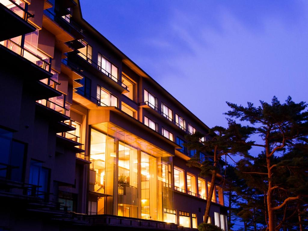 Jodogahama Park Hotel في مياكو: مبنى كبير مع العديد من النوافذ في الليل