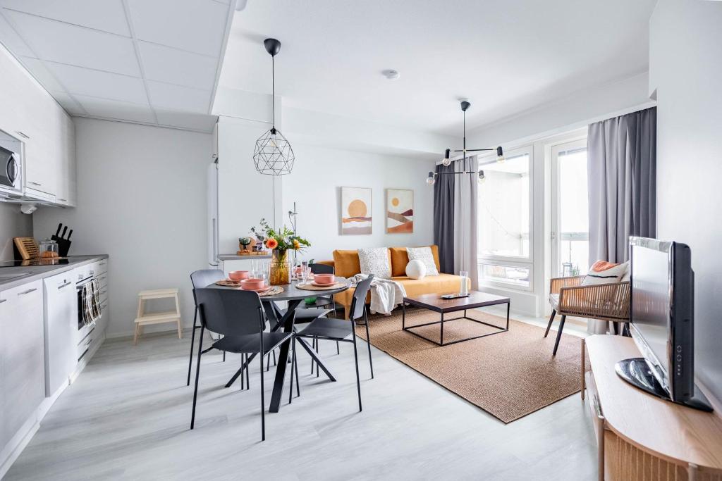 a kitchen and living room with a table and chairs at Arctic Golden Sun City Suite in Rovaniemi