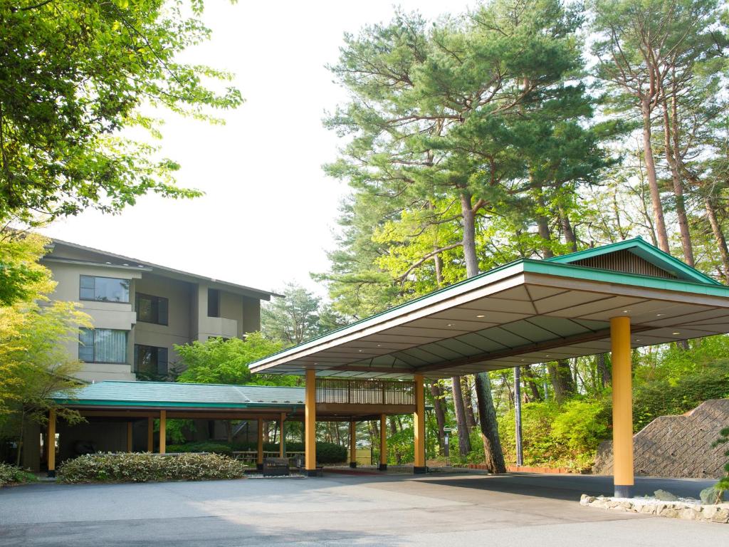 a pavilion in front of a building with trees at Jodogahama Park Hotel in Miyako
