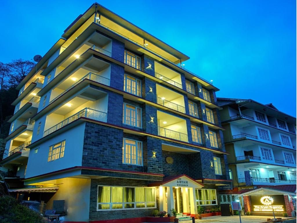a tall building with lights on at Voyage The Aryan Regency in Pelling