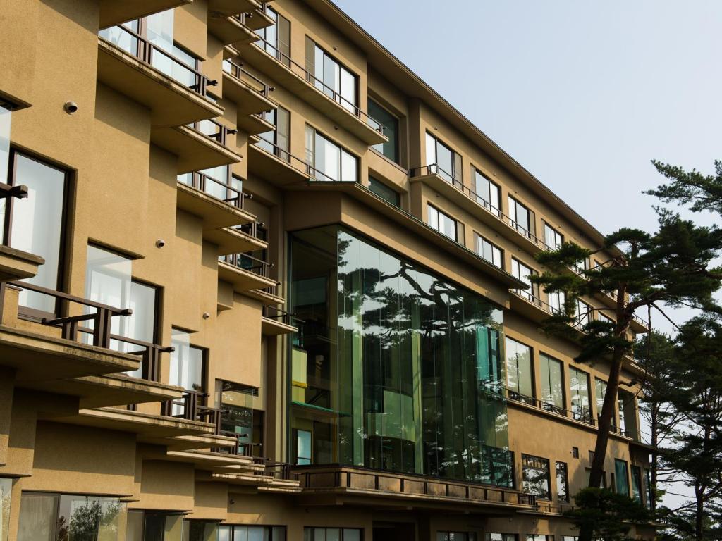 an external view of a building with glass balconies at Jodogahama Park Hotel in Miyako