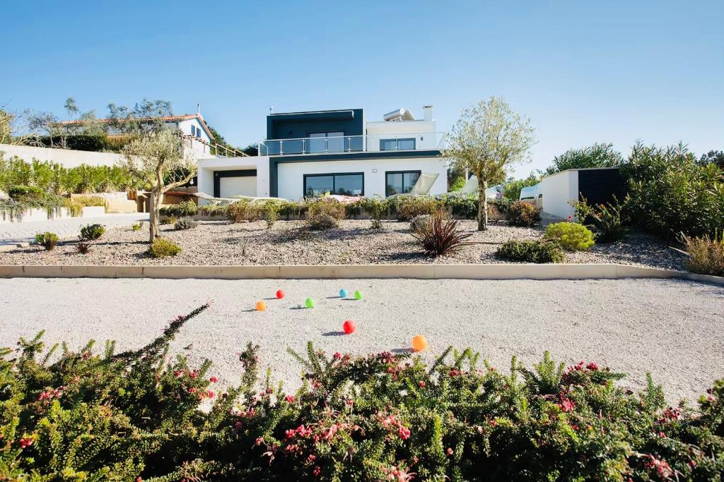 ein Haus mit einem Hof mit Blumen und Pflanzen in der Unterkunft Villa 33 Silver Coast in Nadadouro