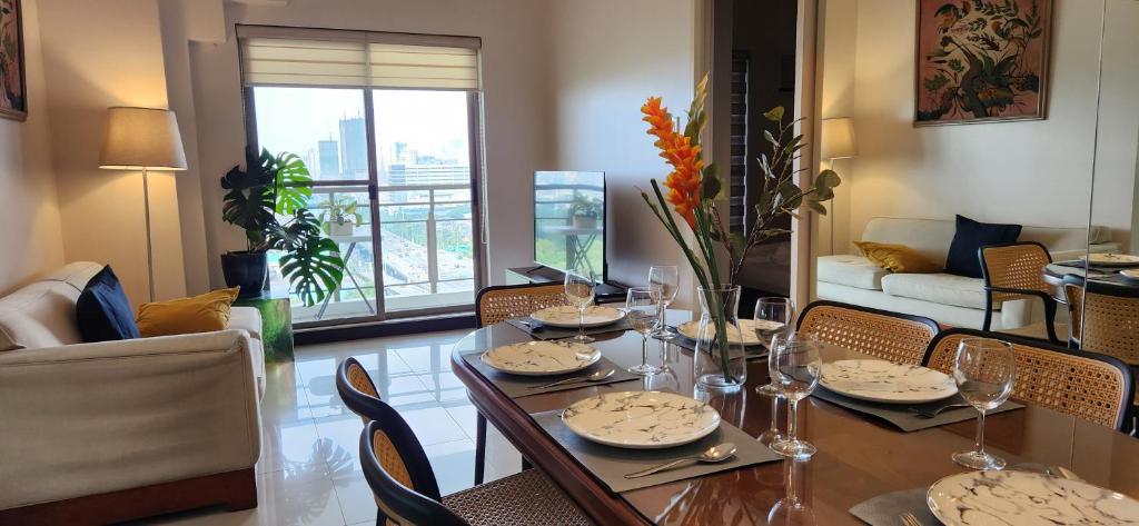 ein Esszimmer mit einem Tisch und Stühlen sowie ein Wohnzimmer in der Unterkunft Casa Antonio at Fairway Terraces Family Penthouse 2BR Wi-Fi Nr Golf, Airport, Fort BGC in Manila