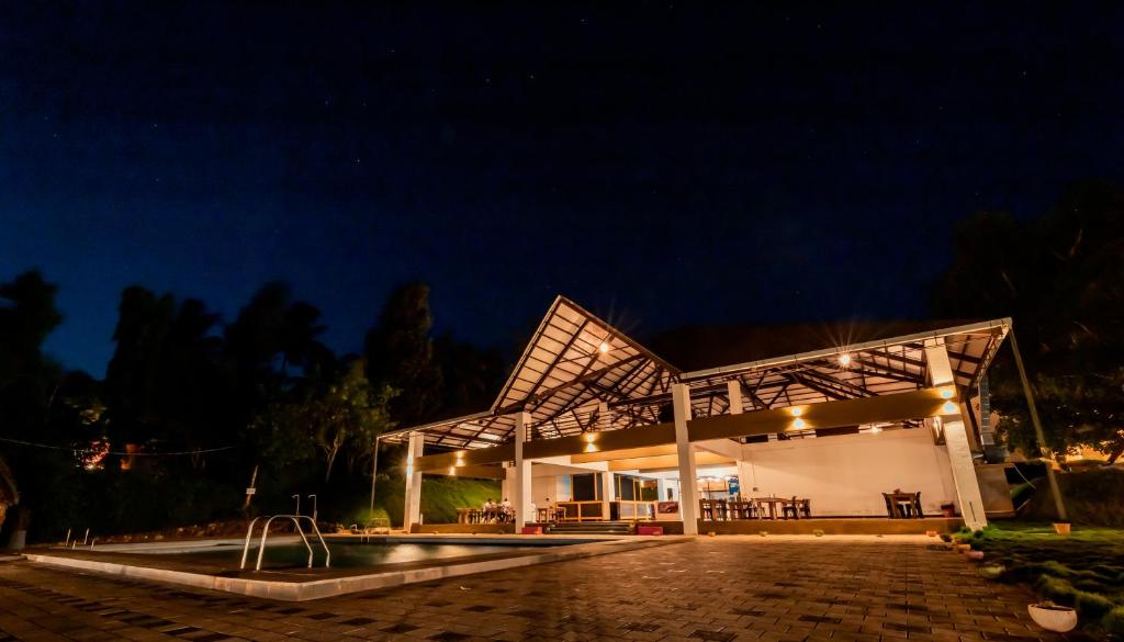 a building with a fountain in front of it at night at Commune18 Resort Chikmagalur in Chikmagalūr