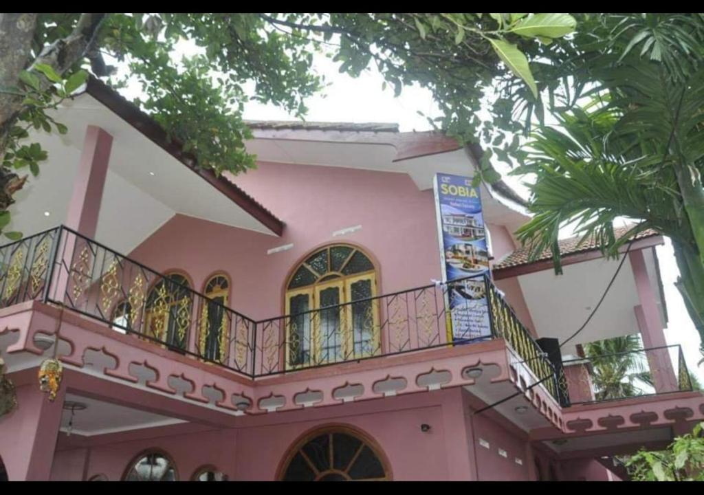 un bâtiment rose avec un balcon en haut. dans l'établissement Sobia Villa, à Jaffna