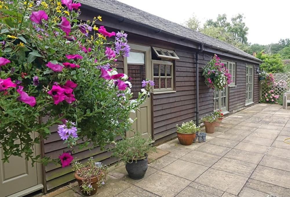 a house with flowers and plants in front of it at Country garden retreat near Henley on Thames in Rotherfield Peppard
