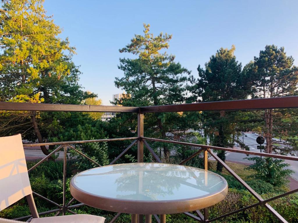 stół i krzesła na balkonie z drzewami w obiekcie Happy Day-Appartement entier de 60 m2 w mieście Douai