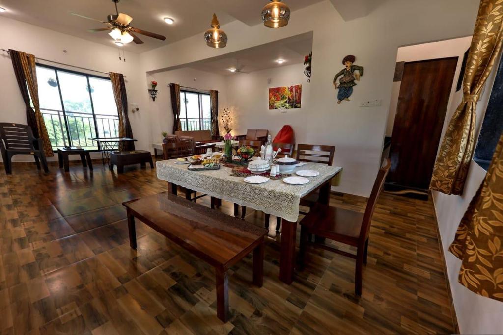 un salon avec une table et une salle à manger dans l'établissement Coral Villa, à Panchgani