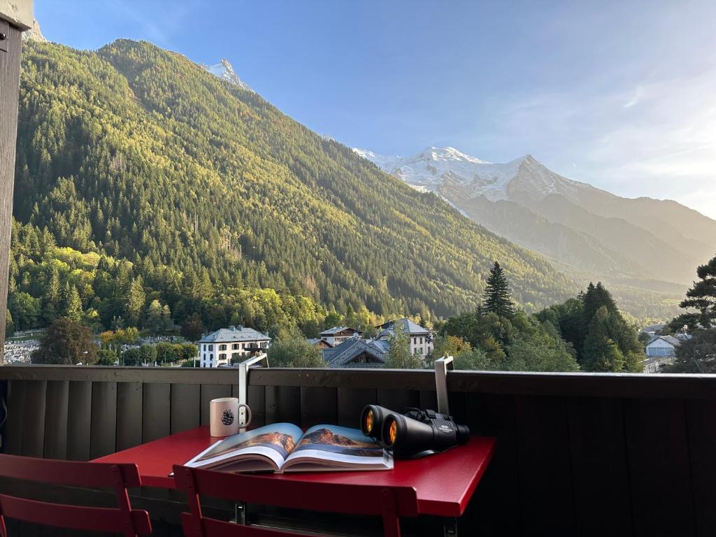 - une table rouge avec des livres sur un balcon avec des montagnes dans l'établissement Center & Unique Mountain View, à Chamonix-Mont-Blanc