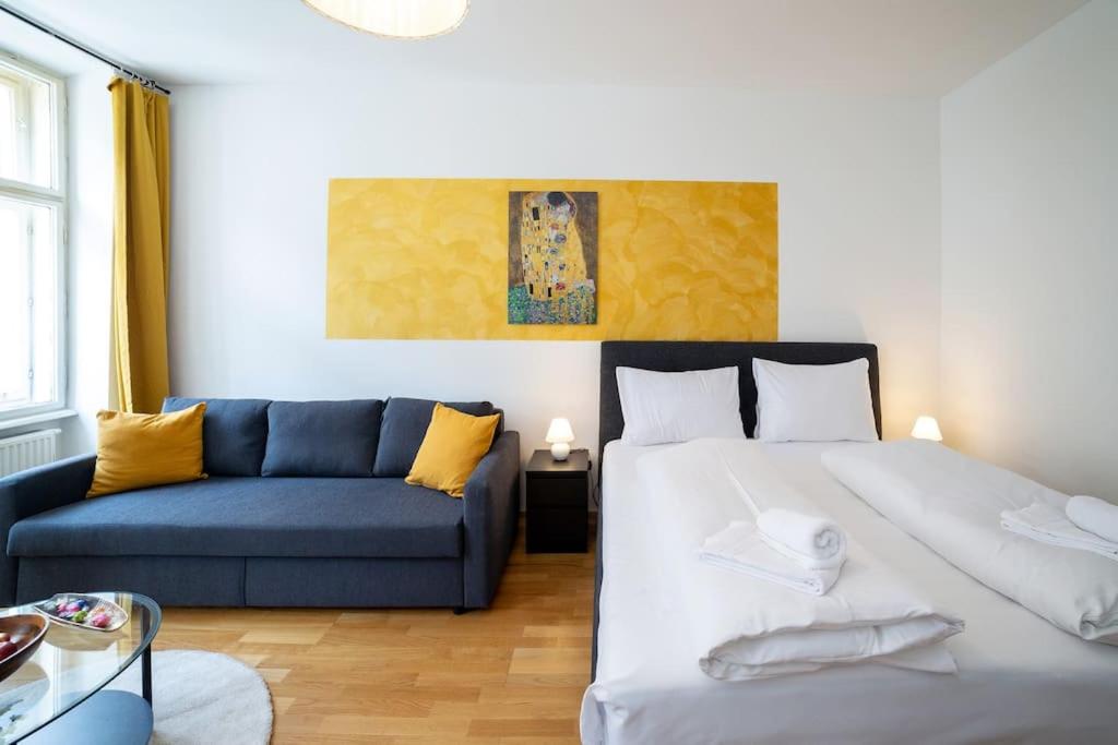 a bedroom with a bed and a blue couch at Sunny and Stylish - Free Parking - 15 min to Center in Vienna