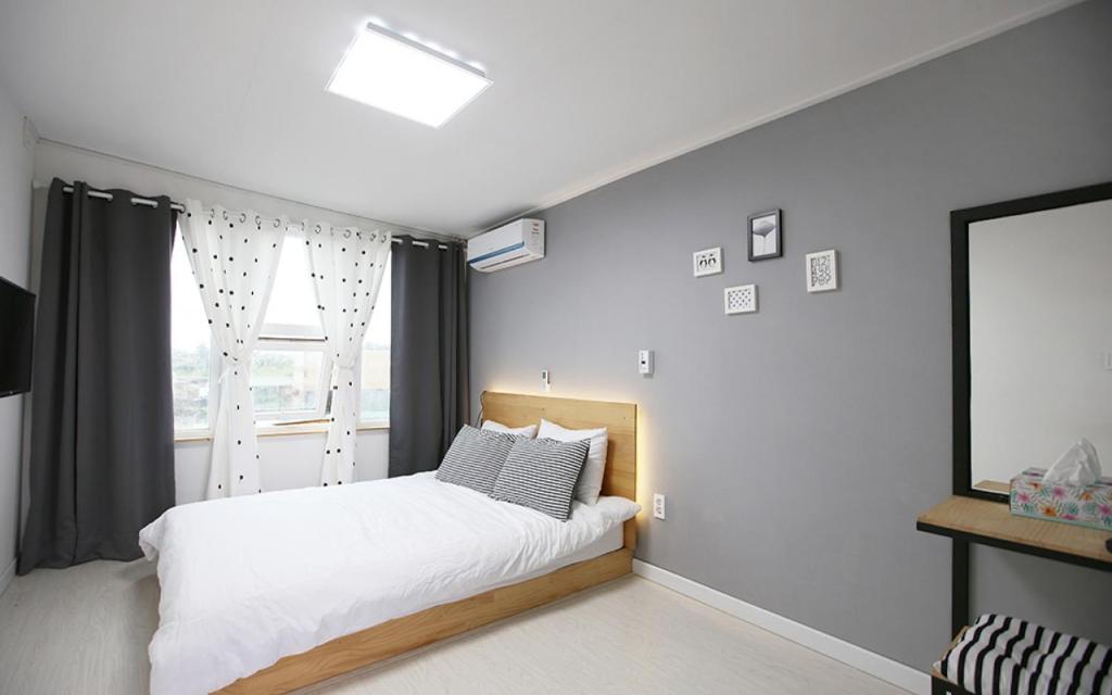 sypialnia z białym łóżkiem i oknem w obiekcie MO Guesthouse w mieście Czedżu
