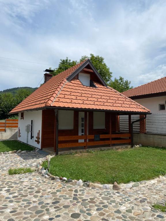 een huis met een oranje dak en een tuin bij Medi Apartman Nature Connection Drina in Bajina Bašta