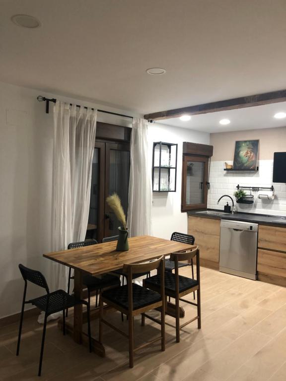 a kitchen and dining room with a wooden table and chairs at Casa de los Abuelos Albino in Pinilla del Valle