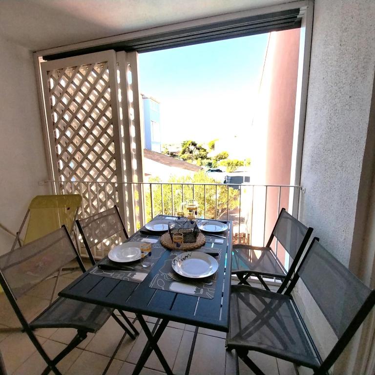 une table bleue et des chaises sur un balcon dans l'établissement Appartement T2 climatisé, 4 couchages, Les Balcons de la Méditerranée, à Narbonne-Plage