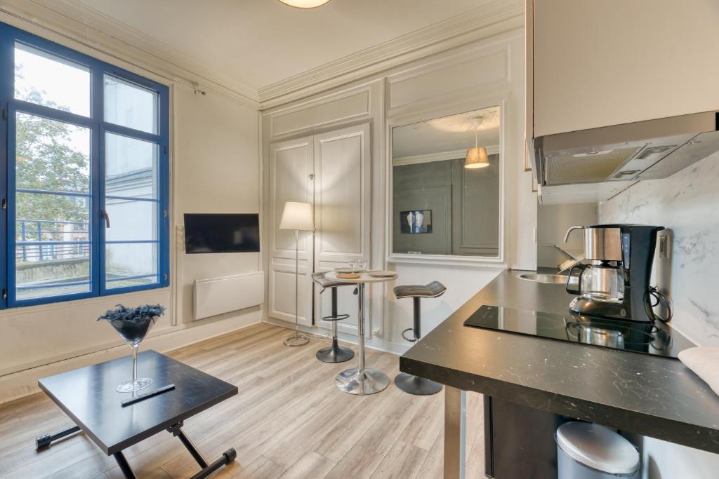 - une cuisine avec un comptoir et une table dans une pièce dans l'établissement Le Black Angel votre studio au cœur de Rouen !, à Rouen