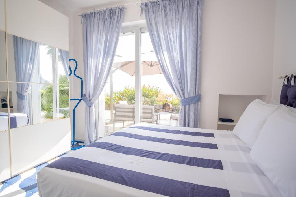 a bedroom with a bed with blue and white curtains at Villa Sterlizia in Capri