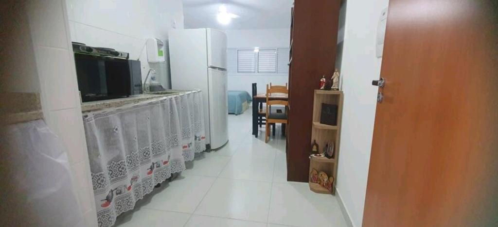eine Küche mit einem Kühlschrank und einem weißen Boden in der Unterkunft Aconchegante no Condomínio da Fê in Cachoeira Paulista
