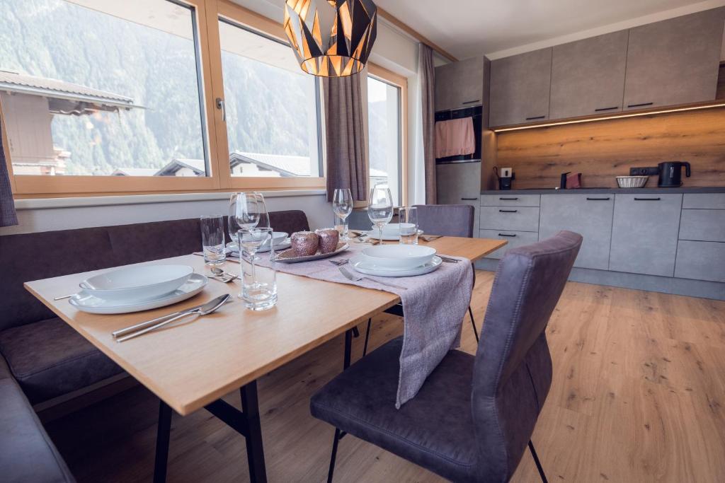 a dining room with a wooden table and chairs at Apart Eder in Schwendau
