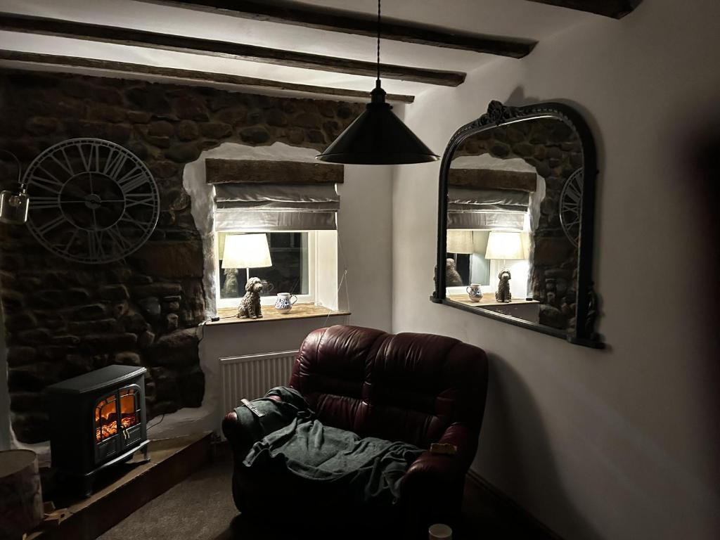 莫克姆的住宿－Cosy 2-Bed Cottage in Heysham Village Morecambe，客厅配有真皮座椅和镜子