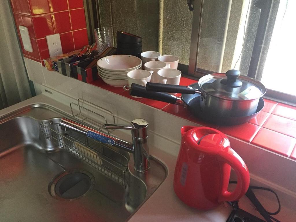 um balcão de cozinha com um lavatório com uma panela e pratos em INARI - Vacation STAY 87349 em Takamatsu