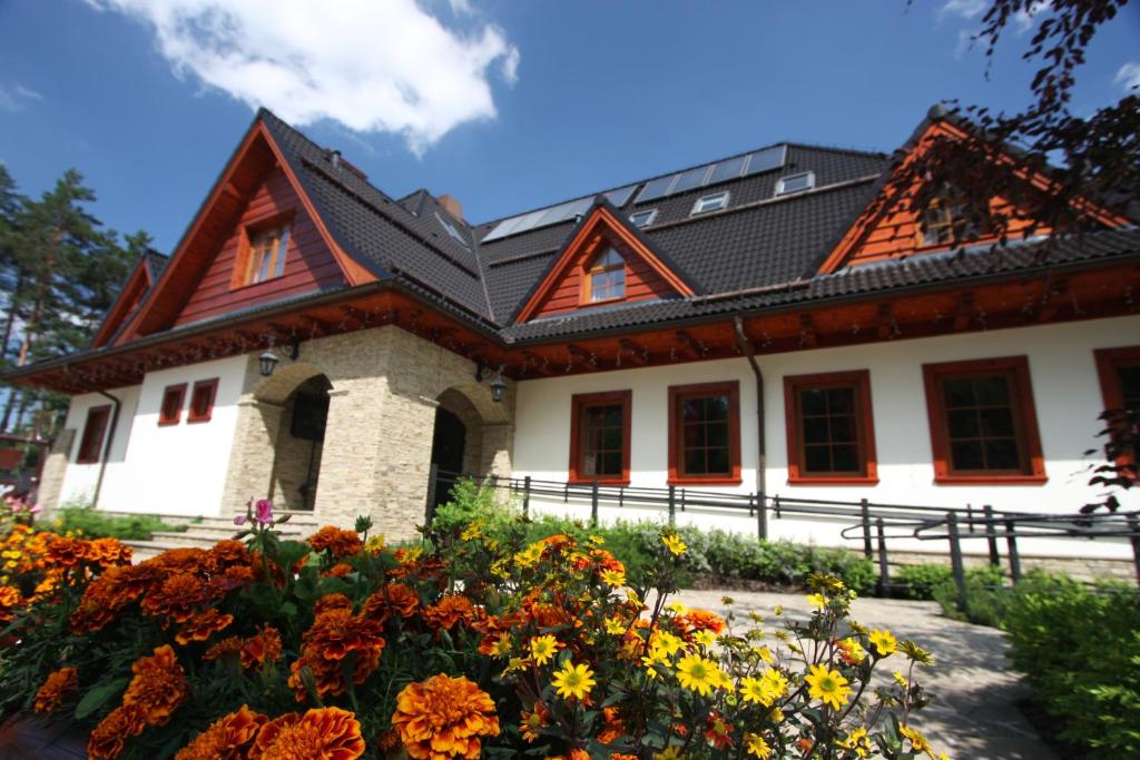 una casa con flores delante en Pokoje w Oberży Czarny Groń en Rzyki