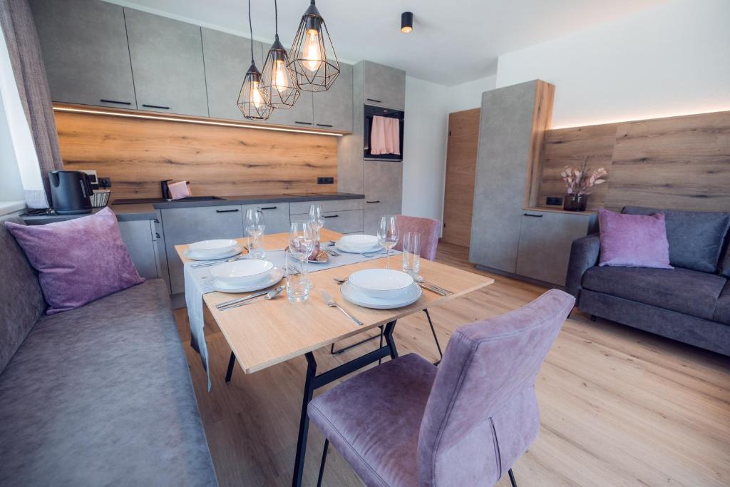 a dining room with a table and a couch at Apart Eder in Schwendau