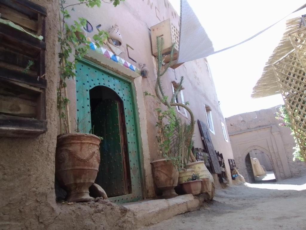 an alley with a building with a green door at Maison d'hôtes tilleli in Tamnougalt