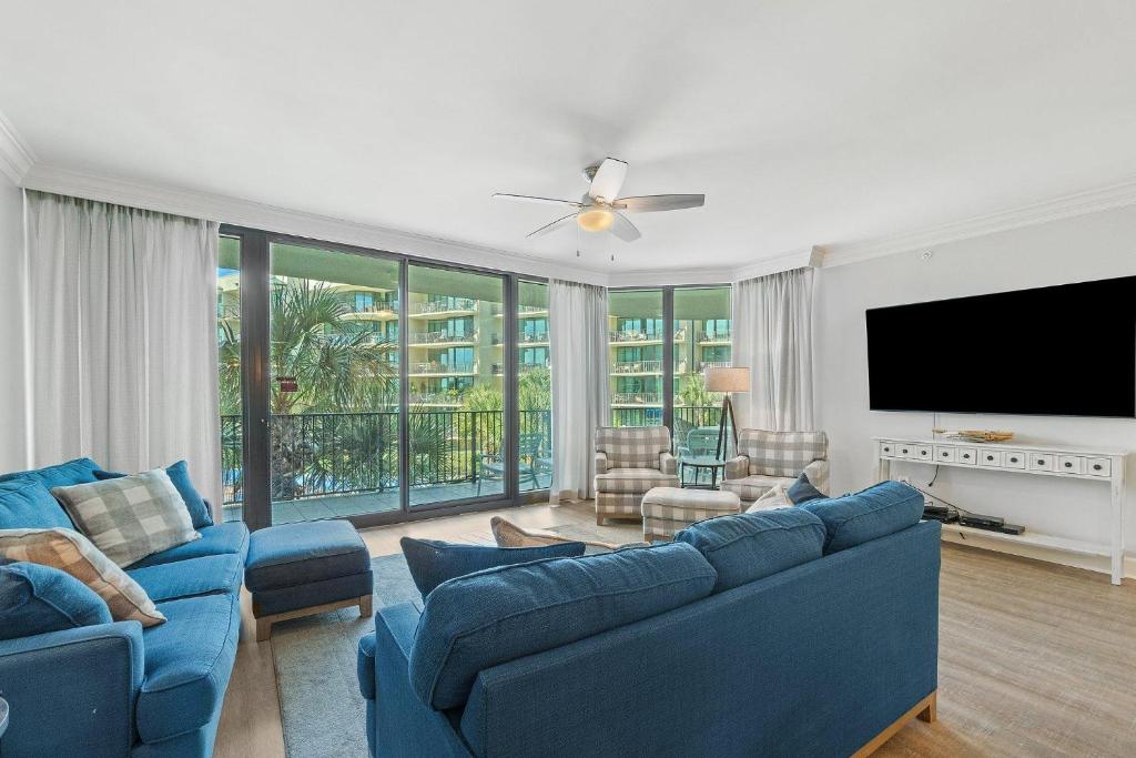 a living room with blue couches and a flat screen tv at Phoenix on the Bay 1228 in Orange Beach