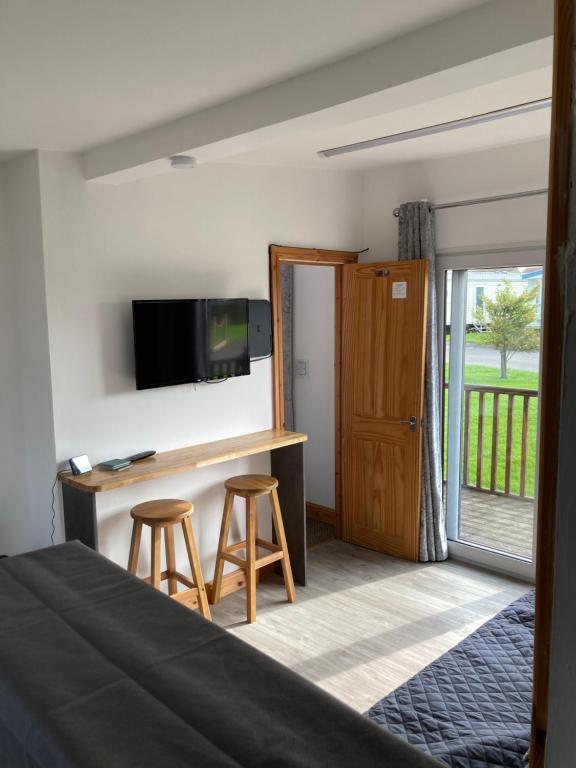 een slaapkamer met een bed en een bureau met 2 krukken bij F17 Rickardos Holiday Lets in Mablethorpe