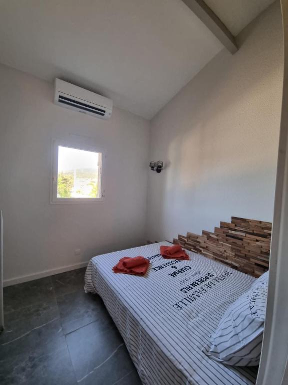 een slaapkamer met een bed met twee rode handdoeken erop bij Petit mazet in Sainte-Maxime