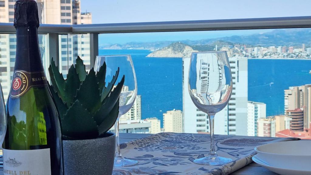 a table with two wine glasses and a cactus at Torre Lugano - Gran terraza con vistas in Benidorm