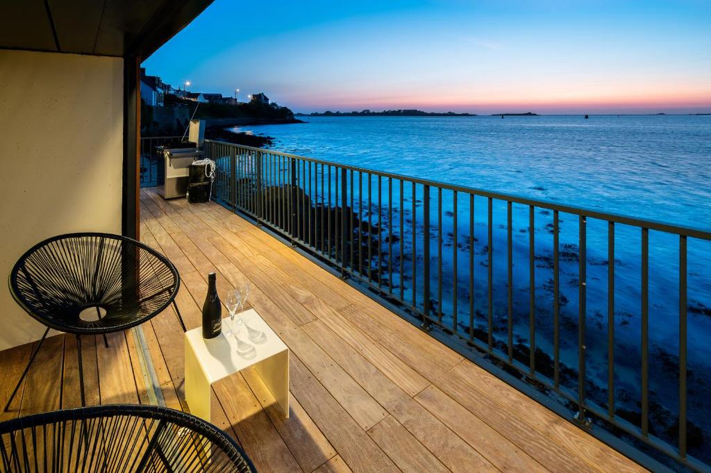 d'un balcon avec une table et des chaises donnant sur l'océan. dans l'établissement ILE CEZON - Duplex de luxe avec magnifique vue mer, à Landéda