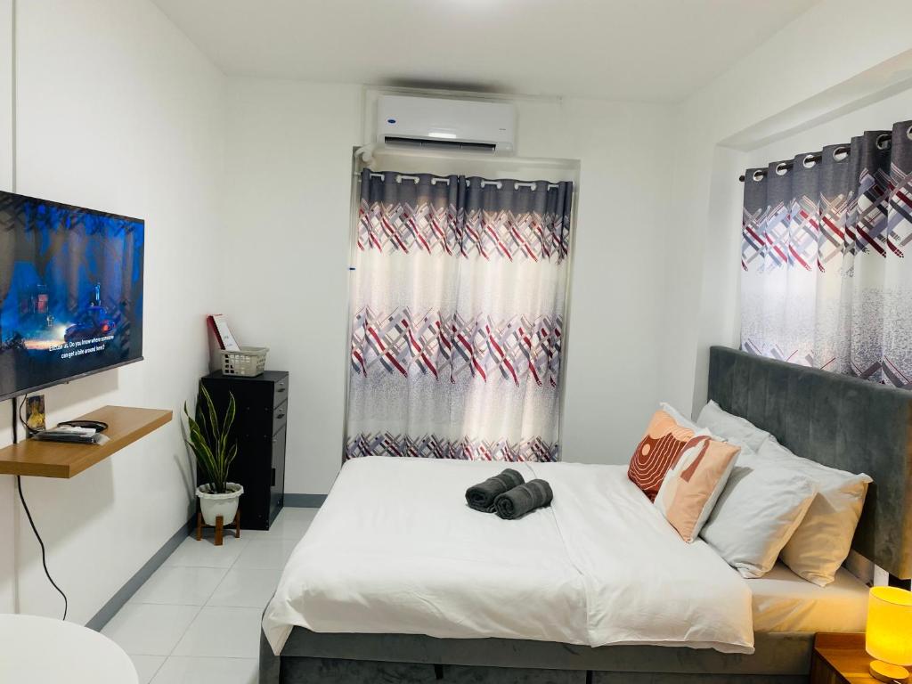 A bed or beds in a room at Condo in EDSA Netflix and SmartTV FreeAccess to POOL and GYM