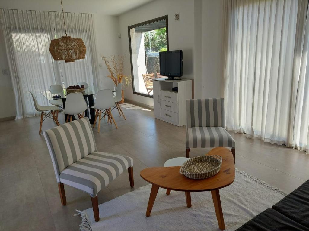 ein Wohnzimmer mit Tisch und Stühlen und einem Fernseher in der Unterkunft Duplex de Categoria - con estacionamiento gratuito in Cordoba