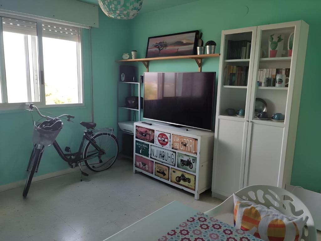 a living room with a flat screen tv and a bike at Casa JRM 'Ribeira Sacra' in Monforte de Lemos